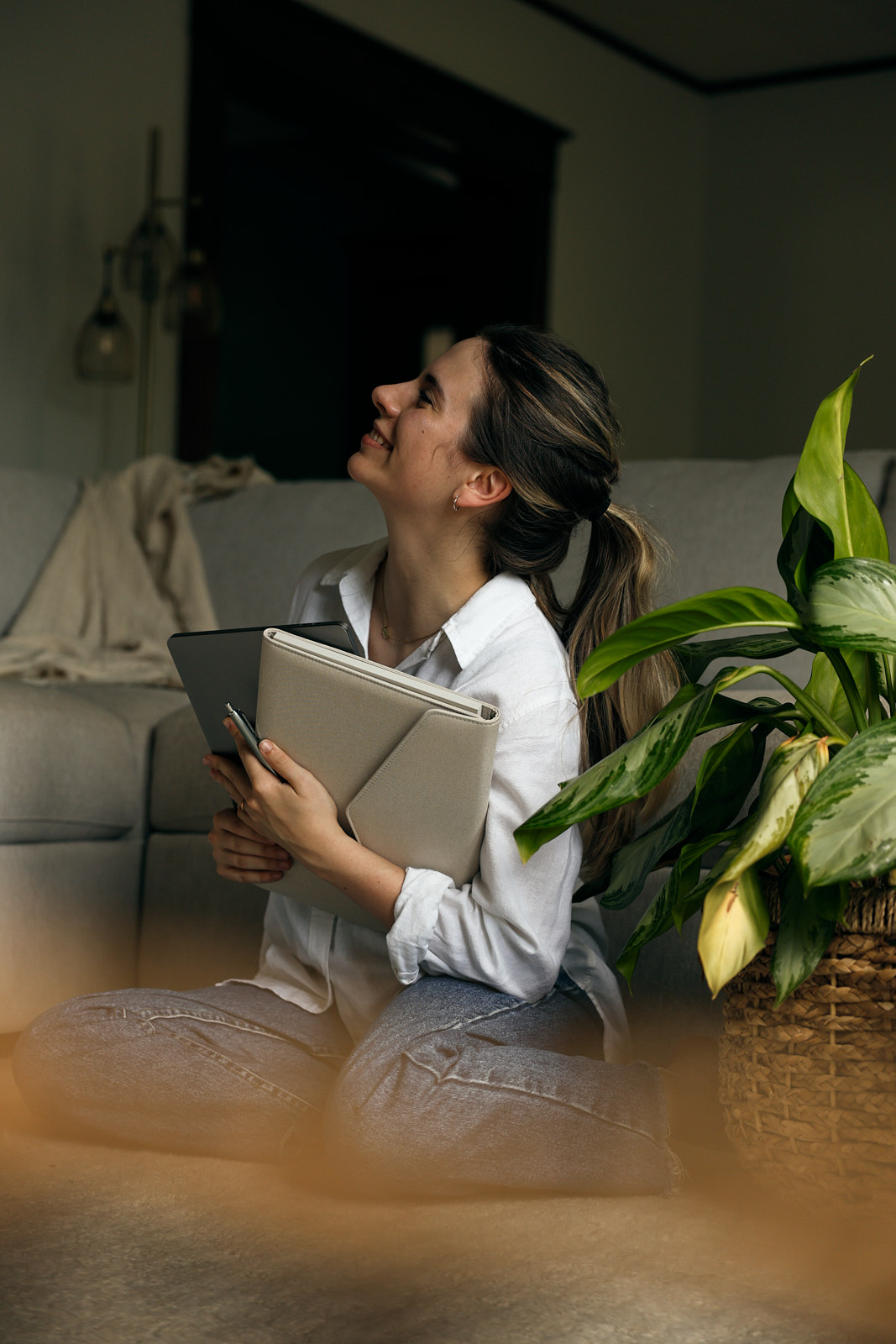 woman sitting on floor with plant and notebook