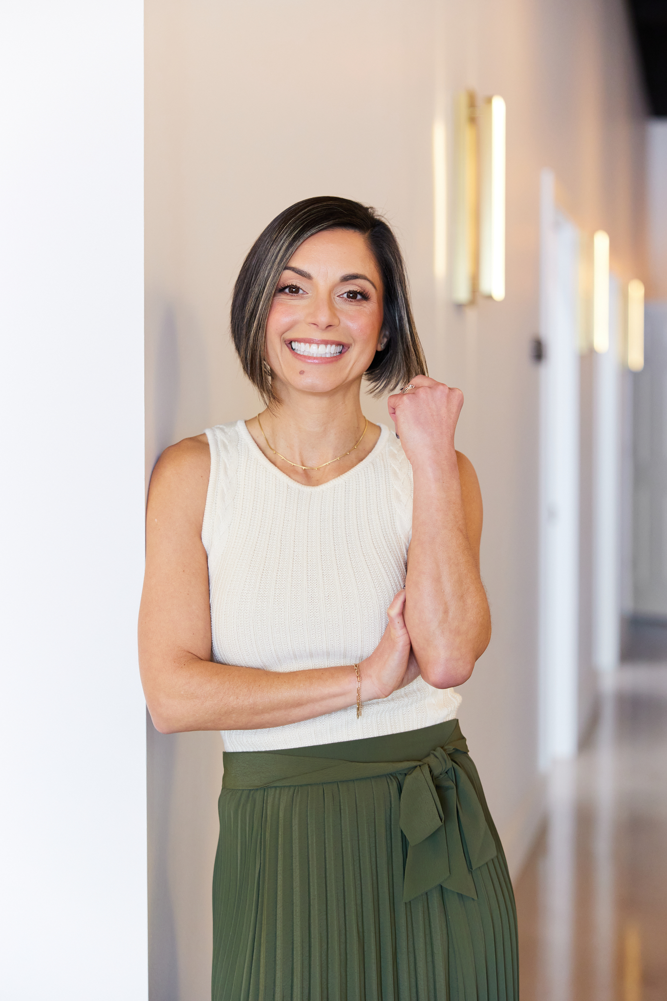 woman standing against wall in green skirt