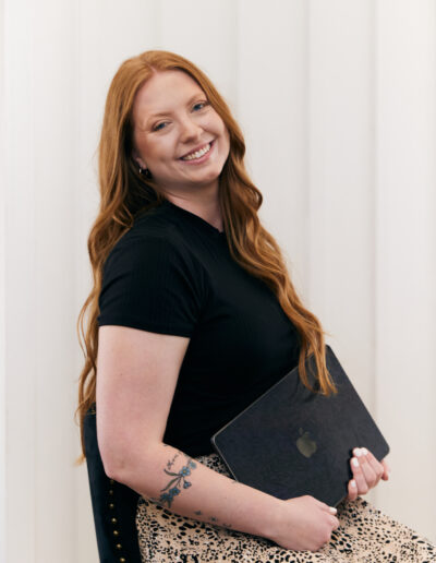 woman with red hair sitting with laptop