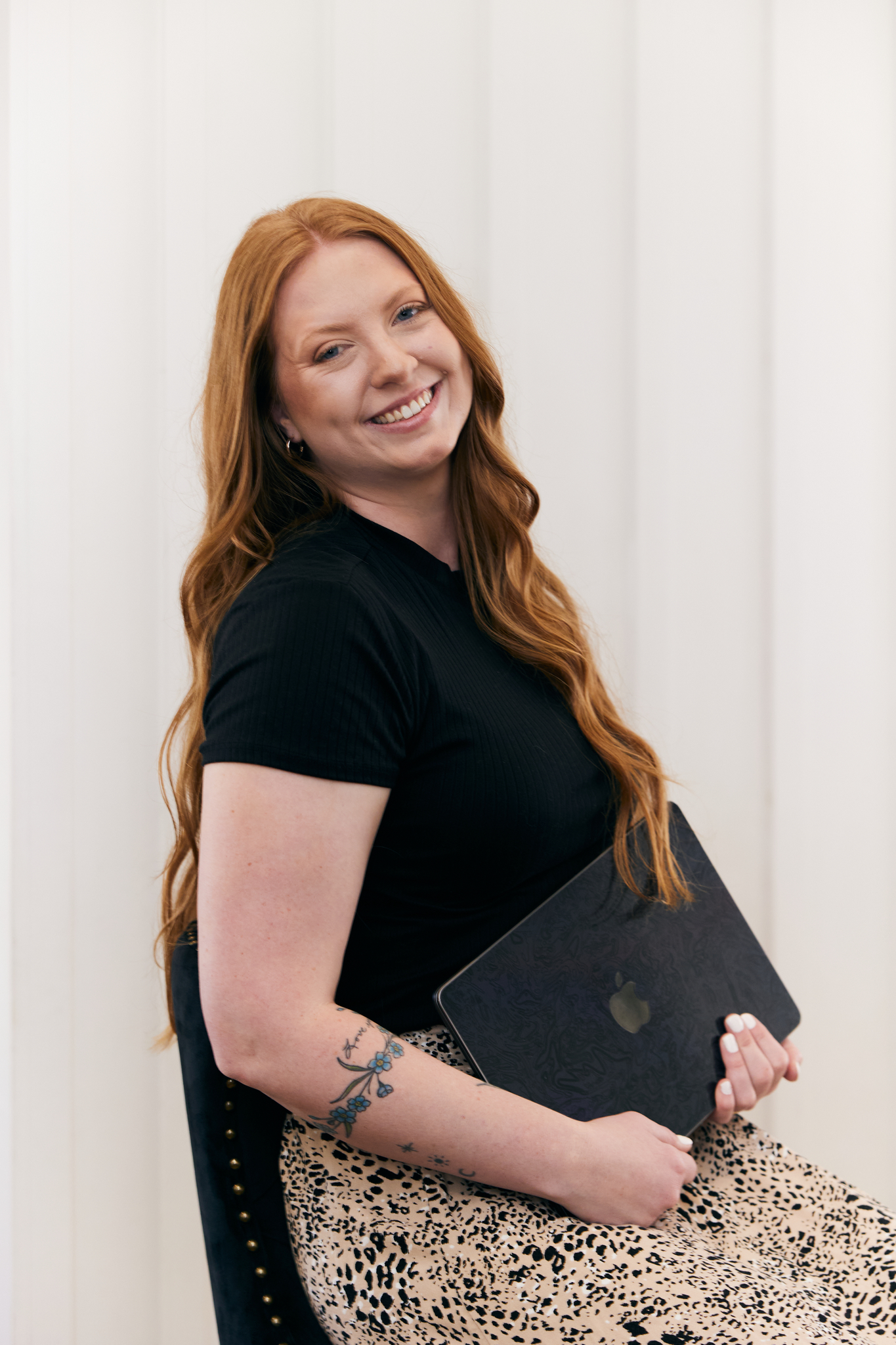 woman with red hair sitting with laptop